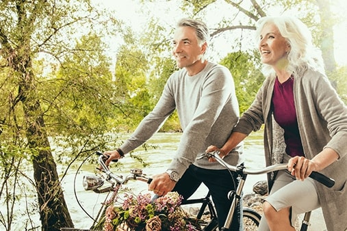 Stariji par sa slušnim pomagalima na biciklu